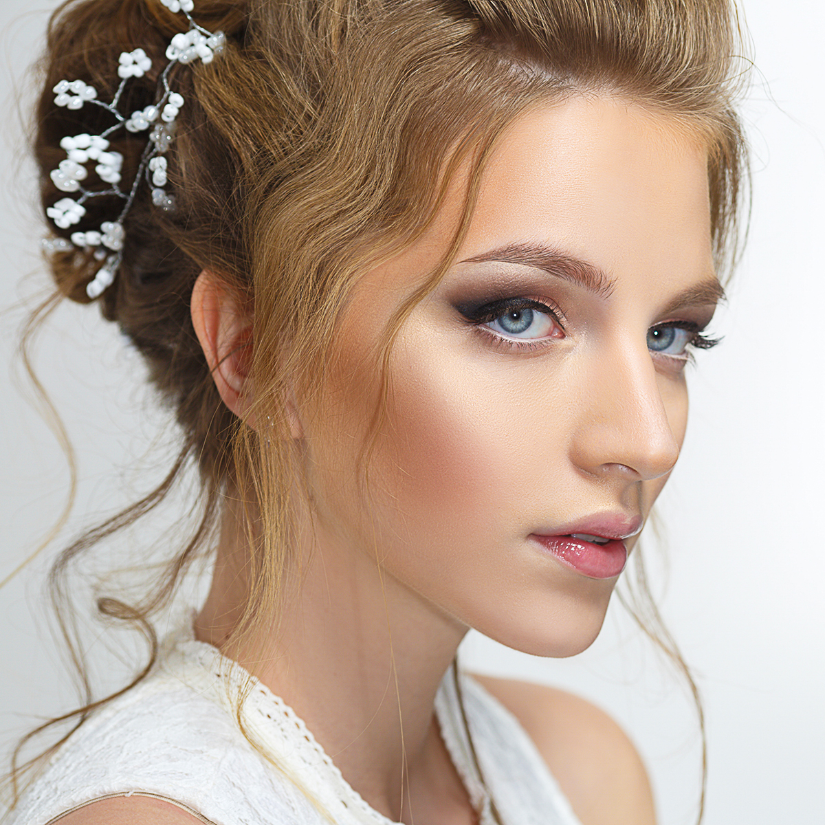 Pretty bride with a gentle make-up isolated on a gray background